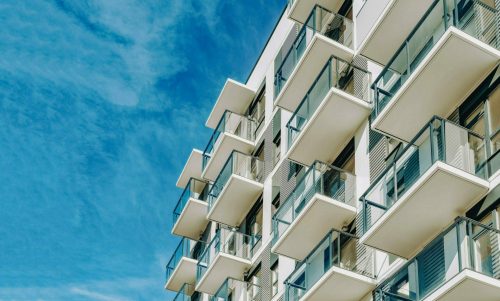 Detail of Modern residential apartment flat building exterior. Fragment of New luxury house and home complex. Part of City Real estate property and condo architecture. Copy space. Blue sky